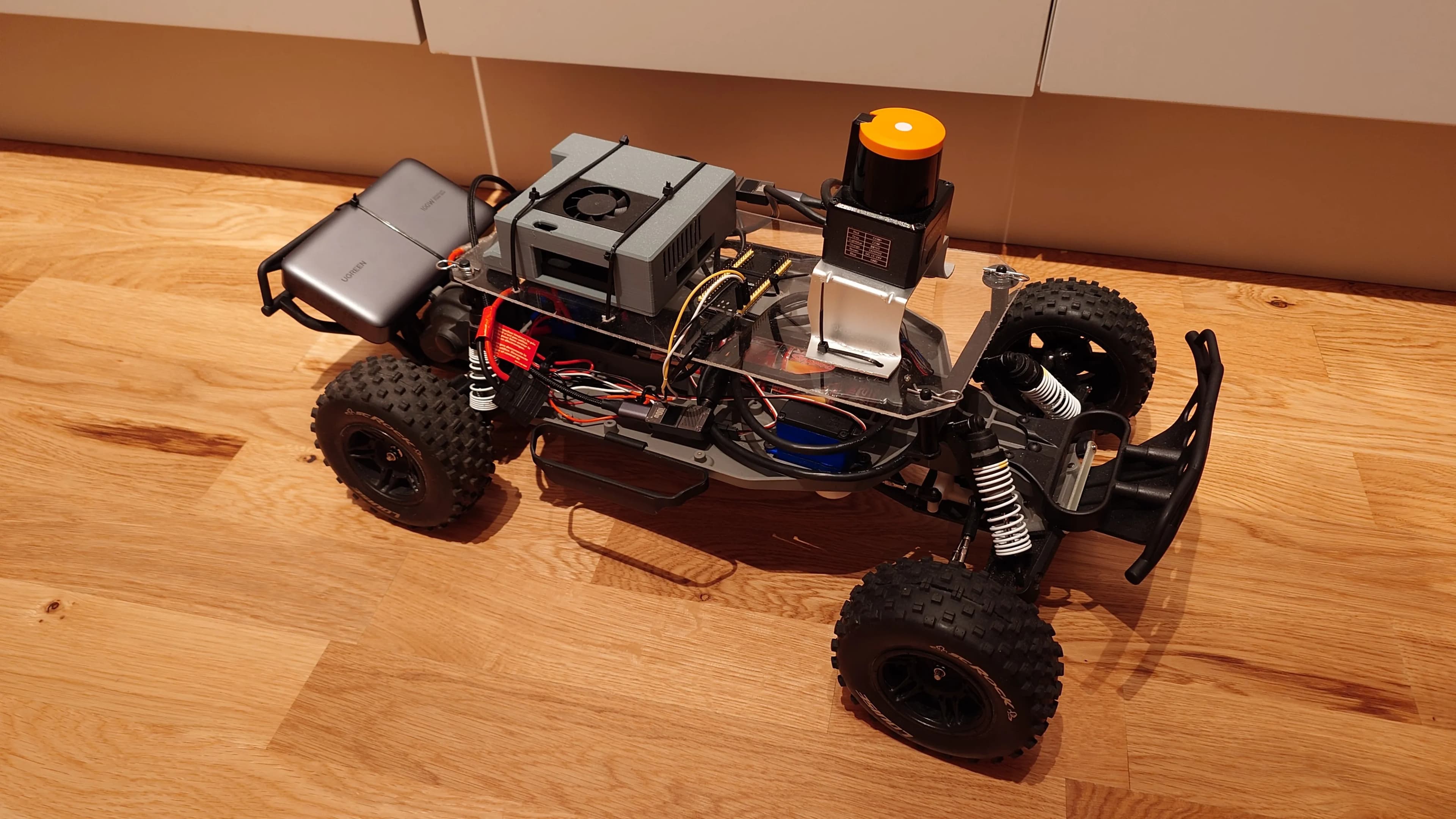 Självkörande radiostyrd bil med monterad Hokuyo LiDAR-sensor och NVIDIA Jetson Orin Nano sedd framifrån.